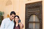 Young couple taking a photograph of themselves with a mobile phone