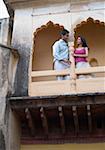 Vue d'angle faible d'un jeune couple s'appuyant sur une colonne d'un palais, Neemrana Fort Palace Neemrana, Alwar, Rajasthan, Inde