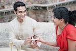 Close-up of a young man giving an engagement ring to a young woman