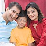 Portrait of a mid adult couple sitting with their son and smiling