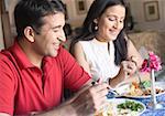 Mid adult couple having food in a restaurant and smiling