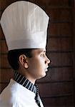 Side profile of a chef in front of a brick wall