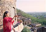 Frau mit Blumen vom Balkon, Neemrana Fort Palace, Neemrana, Alwar, Rajasthan, Indien