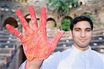 Young man showing his painted hand with powder paint, Neemrana Fort Palace, Neemrana, Alwar, Rajasthan, India