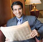 Portrait of a businessman holding a newspaper and smiling