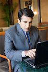 Businessman sitting in an armchair and working on a laptop