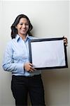 Portrait of a businesswoman holding a blank picture frame and smiling