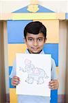 Portrait d'un écolier montrant un dessin