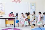 Teacher checking drawings of students in a classroom