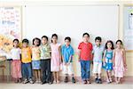 Enfants devant le tableau blanc dans une salle de classe
