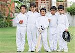 Portrait of five boys standing in a lawn