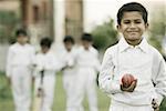 Cricketer holding a cricket ball and smiling