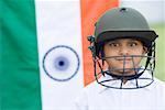 Portrait of a cricket player smiling with an Indian flag in the background