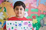 Portrait of a schoolboy holding a drawing