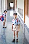 Portrait of a boy standing in the corridor of a school