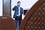 Businessman standing in a conference room and talking on a mobile phone