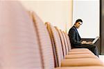 Portrait d'un homme d'affaires travaillant sur un ordinateur portable dans une salle de conférence