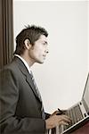 Side profile of a businessman using a laptop on a lectern