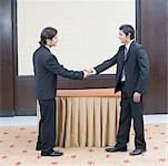 Side profile of two businessmen shaking their hands