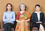 Portrait of three businesswomen sitting on chairs