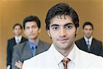 Portrait of a businessman with three business executives standing behind him