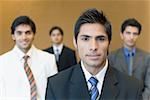 Portrait of a businessman with three business executives standing behind him