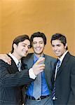 Close-up of three businessmen looking at a mobile phone and smiling