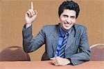 Portrait of a businessman raising his hand and smiling