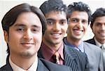 Portrait de quatre hommes d'affaires souriant d'affilée