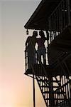 Silhouette of a young couple standing on the beach hut