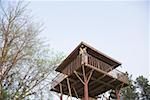 Low angle view of a young couple standing at the railing of a log cabin