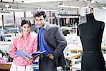 Portrait of a businessman standing with a female fashion designer in a textile industry