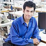 Portrait d'un créateur de mode masculin assis dans une industrie textile