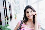 Portrait of a young woman talking on a mobile phone and smiling