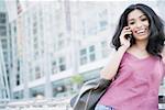 Portrait of a young woman talking on a mobile phone and smiling