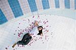 High angle view of a young woman lying in an empty swimming pool