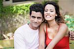 Portrait of a young couple sitting on a bench and smiling