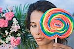 Portrait d'une jeune femme tenant un bonbon