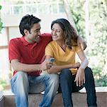 Young man with his arm around a young woman and smiling