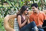 Young couple sitting with a laptop on a couch and smiling