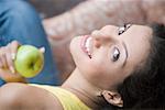 Portrait d'une jeune femme tenant une mamie pomme smith et souriant
