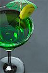 Close-up of a lemon slice and a drink umbrella on a glass of margarita