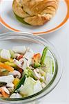 High angle view of a bowl of salad and a plate of bun