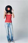 Woman standing and holding a record in front of her face