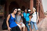 Drei junge Frauen Lächeln mit ihren Freunden, Taj Mahal, Agra, Uttar Pradesh, Indien