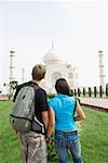 Vue arrière d'un jeune couple en regardant un mausolée, Taj Mahal Agra, Uttar Pradesh, Inde