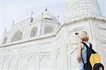 Vue arrière d'une jeune femme de prendre une photo d'un mausolée, Taj Mahal, Agra, Uttar Pradesh, Inde