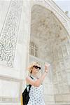 Junge Frau, die eine Aufnahme vor einem Mausoleum, Taj Mahal, Agra, Uttar Pradesh, Indien