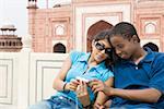 Close-up of a young couple looking at a digital camera, Taj Mahal, Agra, Uttar Pradesh, India