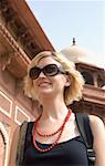 Gros plan d'une jeune femme souriante devant un mausolée, Taj Mahal, Agra, Uttar Pradesh, Inde